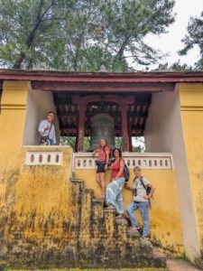 Grupo de turistas posando frente a una fachada amarilla típica de Vietnam.